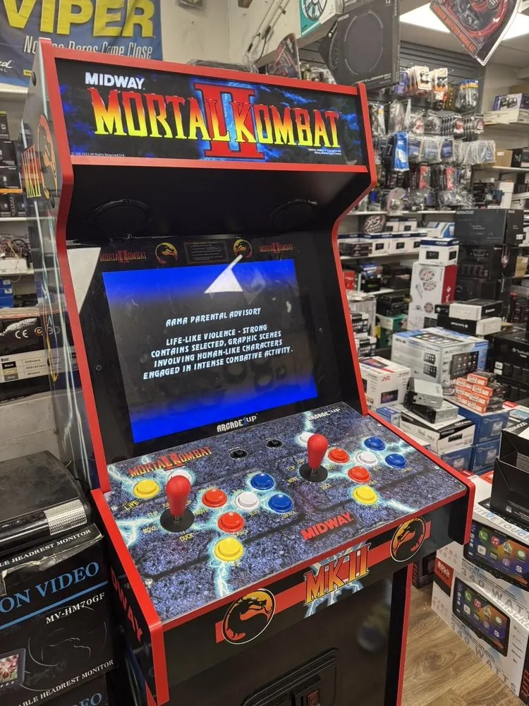 Mortal Kombat II arcade cabinet in the Sound Image showroom surrounded by car audio gear